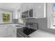 Modern kitchen boasting stainless steel appliances, a gray tile backsplash, and quartz countertops at 1012 Rainey St, Burlington, NC 27217