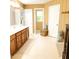 Well-lit bathroom with double vanities, neutral tile flooring, and ample storage space at 102 Kipling Dr, Oxford, NC 27565