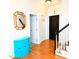 Bright hallway features hardwood floors, a stylish mirror, blue accent cabinet, and staircase at 102 Kipling Dr, Oxford, NC 27565