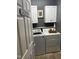 Laundry room with white washer and dryer, cabinets above, and light grey walls at 102 Kipling Dr, Oxford, NC 27565