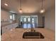 Open-concept kitchen with granite countertops, stainless sink, and views of the living area at 1033 Bostonian Dr, Knightdale, NC 27545