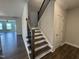 Staircase with wood stairs, a dark wood banister, and hardwood flooring on the first floor at 1033 Bostonian Dr, Knightdale, NC 27545