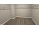 Spacious walk-in closet featuring carpeted floors and metal shelving for organized storage at 1033 Bostonian Dr, Knightdale, NC 27545