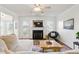 Bright living room featuring a fireplace, ceiling fan, comfortable seating, and access to the outdoors at 108 Hudson Dr, Princeton, NC 27569