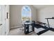 Bright home office with large arched window, modern desk setup, and exercise equipment for a balanced lifestyle at 108 Hudson Dr, Princeton, NC 27569