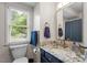 Modern bathroom featuring a vanity with granite countertop, updated fixtures, and a window at 111 Killam Ct # 2A, Cary, NC 27513
