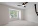 Bright, carpeted bedroom featuring a ceiling fan and large window providing natural light at 111 Killam Ct # 2A, Cary, NC 27513