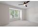 Bright, carpeted bedroom featuring a ceiling fan and large window providing natural light at 111 Killam Ct # 2A, Cary, NC 27513