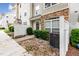 Close-up of a townhouse entrance with stone accents and manicured bushes at 1220 Canyon Rock Ct # 107, Raleigh, NC 27610