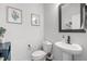 Well-lit half bath with a pedestal sink, framed art and a decorative mirror at 1236 Shadow Shade, Wake Forest, NC 27587