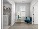 Bright hallway nook featuring a plush chair, accent table, and easy access to laundry at 1236 Shadow Shade, Wake Forest, NC 27587
