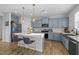 Contemporary kitchen with blue cabinets, an island with seating, and modern stainless steel appliances at 1236 Shadow Shade, Wake Forest, NC 27587