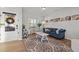 Comfortable living room showcasing a plush blue sofa, hardwood floors, and a decorative wreath on the door at 1236 Shadow Shade, Wake Forest, NC 27587