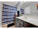Bathroom with blue-striped shower curtain, white sink and vanity, and simple wall decor at 128 Christy Ln, Dunn, NC 28334