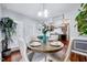 Dining room with wood table, neutral chairs, wainscoting, and view into bright kitchen at 128 Christy Ln, Dunn, NC 28334