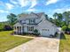 Charming two-story home with attached garage, well-manicured lawn, and inviting front porch at 128 Christy Ln, Dunn, NC 28334