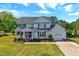 Charming two-story home with attached garage, well-manicured lawn, and inviting front porch at 128 Christy Ln, Dunn, NC 28334