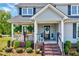 Inviting covered front porch with comfortable seating and beautiful landscaping around the entryway at 128 Christy Ln, Dunn, NC 28334