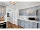 Bright kitchen featuring gray cabinets, wood floors, stainless steel appliances, and marble countertops at 128 Christy Ln, Dunn, NC 28334