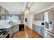 Well-lit kitchen features gray cabinets, wood floors, stainless steel appliances, and a stylish light fixture at 128 Christy Ln, Dunn, NC 28334