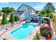 Backyard oasis with a beautiful pool, well-maintained landscaping, and an inviting outdoor seating area with multiple umbrellas at 128 Christy Ln, Dunn, NC 28334