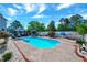 Sparkling in-ground pool surrounded by a patio, lush landscaping, and comfortable seating areas at 128 Christy Ln, Dunn, NC 28334