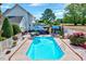 Well-kept pool surrounded by flowers and multiple seating options to create a relaxing backyard retreat with meticulous landscaping at 128 Christy Ln, Dunn, NC 28334