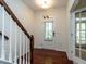 Bright foyer with hardwood floors, a staircase with white railings, and a glass-paneled door providing natural light at 1314 Cornell Pl, Raleigh, NC 27607