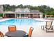 Community pool with lounge chairs and tables offers a relaxing retreat with a clubhouse in the background at 1314 Cornell Pl, Raleigh, NC 27607