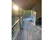 View of covered back porch featuring wood floors and wood railing with string lights at 1345 Ellis Rd, Durham, NC 27703