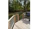 Backyard deck with a grill and an outdoor space surrounded by mature trees at 1345 Ellis Rd, Durham, NC 27703