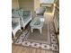 Comfortable porch with wicker seating, glass top table, and decorative outdoor rug at 1345 Ellis Rd, Durham, NC 27703