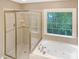 Elegant bathroom with a glass-enclosed shower and a large soaking tub at 150 Remington Ct, Youngsville, NC 27596