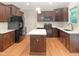 Well-equipped kitchen with stainless steel appliances, island, and beautiful wood floors at 150 Remington Ct, Youngsville, NC 27596