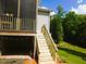 Wooden stairs leading to a backyard deck with string lights under the decking at 187 Ashley Woods Ct, Clayton, NC 27527