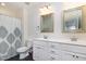 Bright bathroom features a double sink vanity, patterned shower curtain, and modern fixtures at 187 Ashley Woods Ct, Clayton, NC 27527