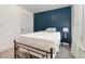 Cozy bedroom with a metal bed frame, a blue accent wall, and a window letting in natural light at 187 Ashley Woods Ct, Clayton, NC 27527