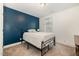Cozy bedroom with a metal bed frame, a blue accent wall, and a window letting in natural light at 187 Ashley Woods Ct, Clayton, NC 27527