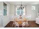 Bright dining area with a wooden table, chandelier, wainscotting, and natural light from windows at 187 Ashley Woods Ct, Clayton, NC 27527