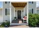 Inviting front porch with a decorative wreath, a wooden bench with pillows, and stylish wall sconces at 187 Ashley Woods Ct, Clayton, NC 27527