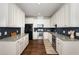 Galley kitchen with stainless steel appliances, granite countertops, and sleek white cabinetry at 187 Ashley Woods Ct, Clayton, NC 27527