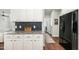 Bright kitchen features white cabinets, granite countertops, and dark backsplash, offering a modern and stylish cooking space at 187 Ashley Woods Ct, Clayton, NC 27527