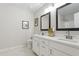 Bathroom with double sink vanity, neutral walls, and a decorative mirror at 20 Meadowcrest Dr, Durham, NC 27703