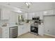 Modern kitchen featuring stainless steel appliances, sleek white cabinets, and light blue backsplash at 20 Meadowcrest Dr, Durham, NC 27703