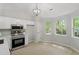 Bright eat-in kitchen featuring stainless steel appliances, white cabinets, and hardwood floors at 20 Meadowcrest Dr, Durham, NC 27703