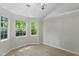 Sunlit living room with hardwood floors, large windows, and neutral paint at 20 Meadowcrest Dr, Durham, NC 27703
