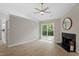 Bright living room with fireplace, modern ceiling fan, and sliding glass door to the backyard at 20 Meadowcrest Dr, Durham, NC 27703