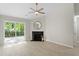 Bright living room with fireplace, modern ceiling fan, and sliding glass door to the backyard at 20 Meadowcrest Dr, Durham, NC 27703