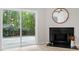 Bright living room with fireplace, modern ceiling fan, and sliding glass door to the backyard at 20 Meadowcrest Dr, Durham, NC 27703