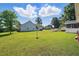This beautiful home features a spacious backyard with lush green grass and mature trees at 203 Marlowe Dr, Dunn, NC 28334